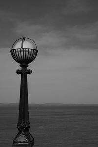 Ferris wheel by sea against sky