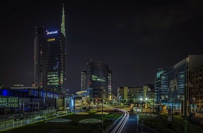 Illuminated buildings in city against sky at night