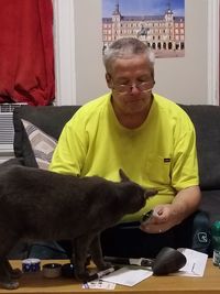 Man with cat sitting on table