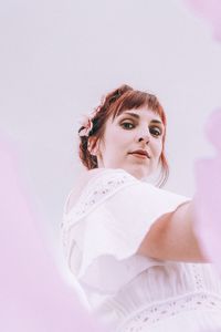 Portrait of young woman against gray background