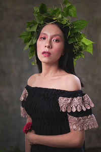 Portrait of a beautiful young woman standing against plants