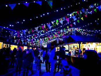 People at illuminated market stall