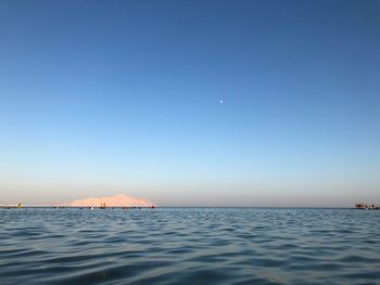 Scenic view of sea against clear blue sky