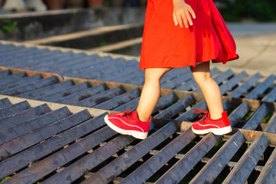 Low section of girl walking on metal