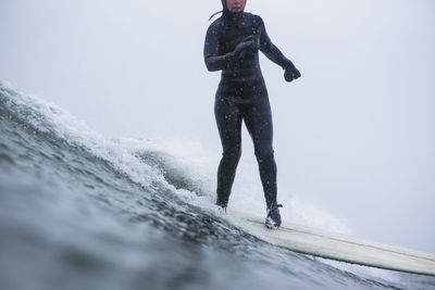 Woman surfing during winter snow