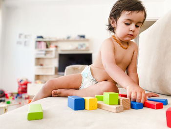 Portrait of young woman exercising with toy blocks at home