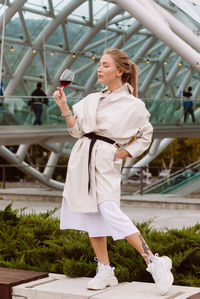 Young woman drinking wine in the park