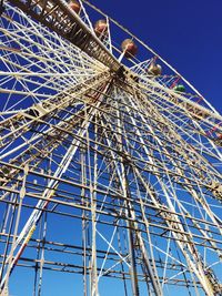 Low angle view of ferris wheel against blue sky