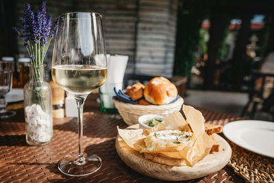 Glass of cold white wine and oven baked camembert cheese