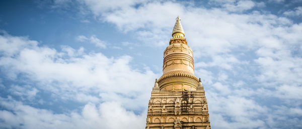 Low angle view of pagoda against cloudy sky