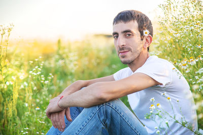 Portrait of man sitting on field