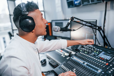 Setting the equipment. young man is indoors in the radio studio is busy by broadcast.