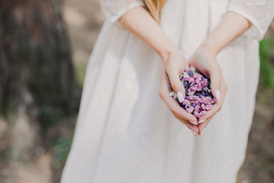 Midsection of woman holding flowers