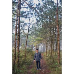 Full length portrait of man standing in forest