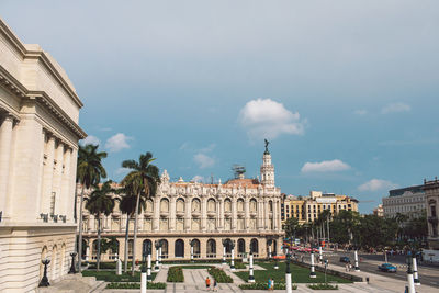 Buildings in town against cloudy sky