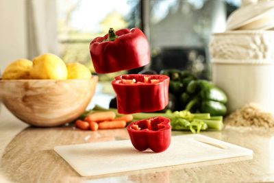 Close-up of flying chopped bell pepper on table