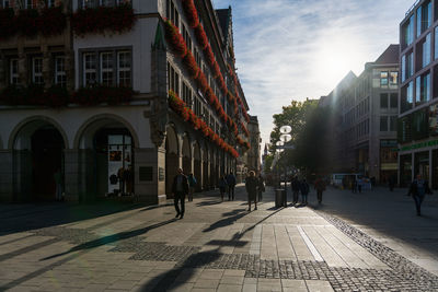 People walking on street amidst buildings in city