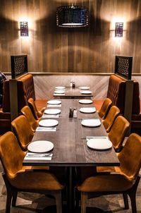 Empty chairs and tables in illuminated restaurant