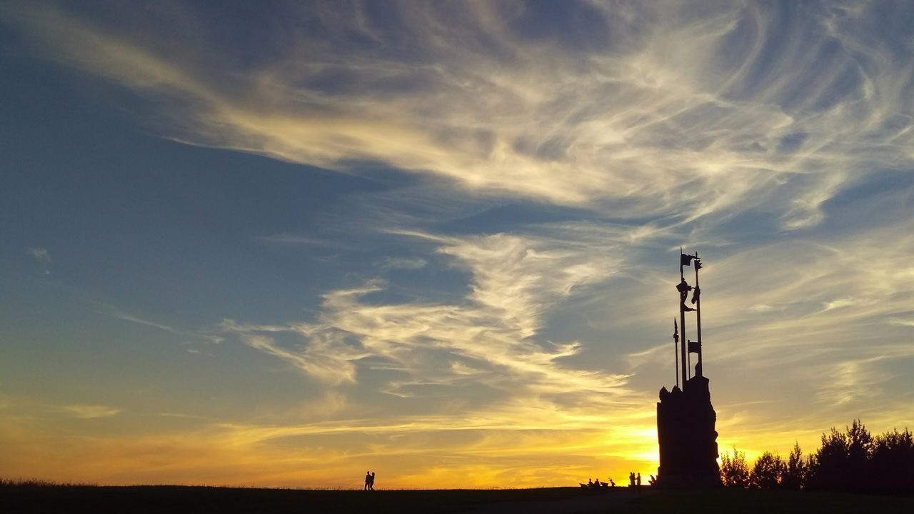 SILHOUETTE OF BUILDING AGAINST CLOUDY SKY DURING SUNSET