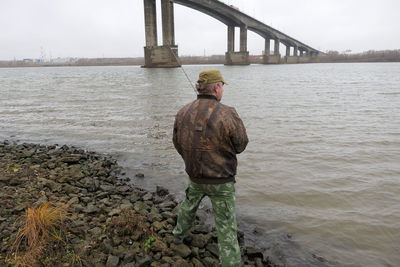 Rear view of man standing at beach