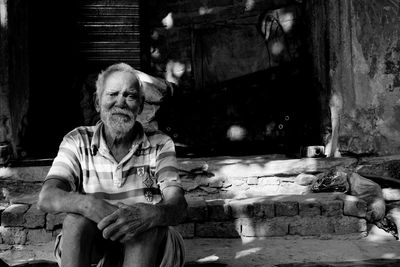 Portrait of man sitting outside building