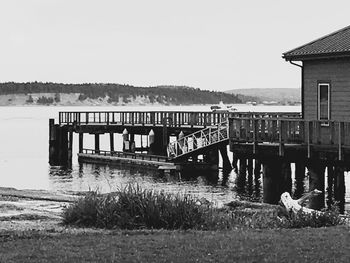 Pier over calm lake against clear sky