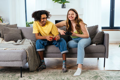 Portrait of young woman sitting on sofa at home