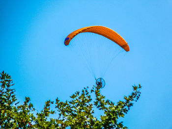 Low angle view of parachute against clear blue sky