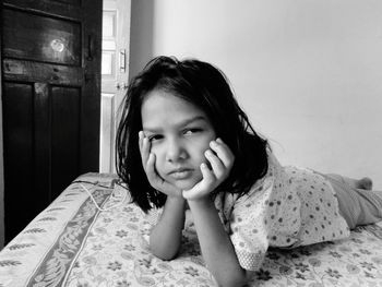 Portrait of girl lying on bed at home