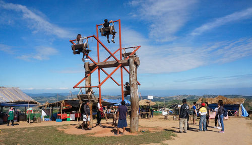 People at sea shore against sky