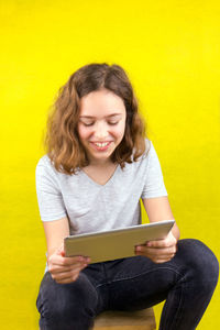 Portrait of smiling girl holding smart phone