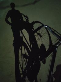 Silhouette man riding bicycle on street