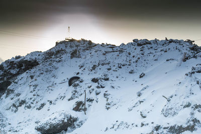 Low angle view of snow covered mountain against sky