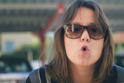 Portrait of mid adult woman wearing sunglasses while making face