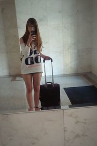 Woman standing by wall