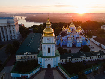 Buildings in city against sky during sunset