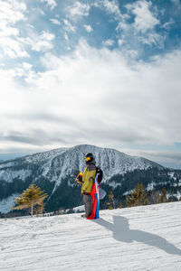 Full length of woman standing on snow covered mountain