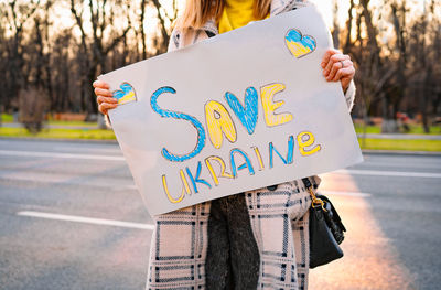 Midsection of woman holding paper