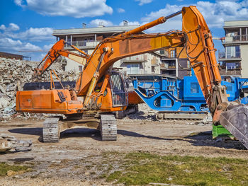 An orange excavator at a construction site