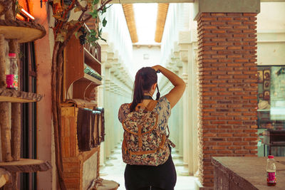 Rear view of woman standing in corridor