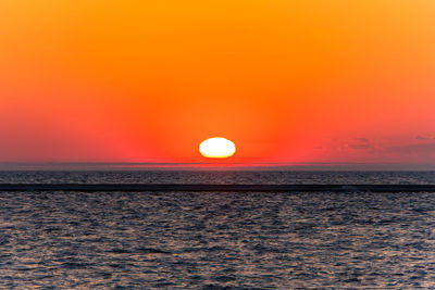 Scenic view of sea against romantic sky at sunset