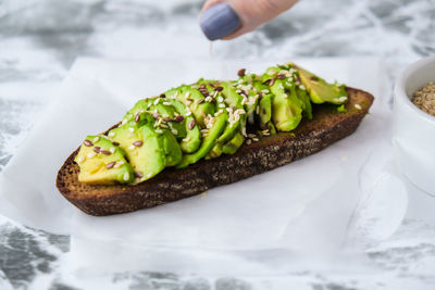 Healthy avocado toast on concrete background. wholegrain bread, sesame flax seeds. vegan keto diet. 