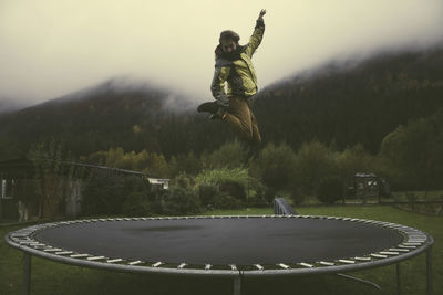 Man jumping in park against sky