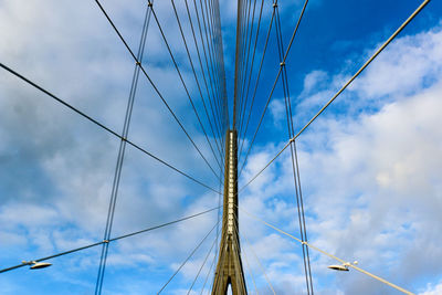 Low angle view of cable-stayed bridge against cloudy sky