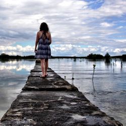 Man standing on jetty in lake