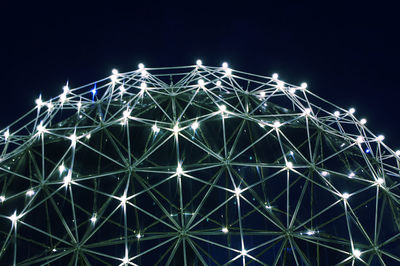 Low angle view of illuminated ferris wheel against sky at night