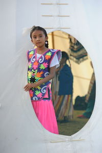 Smiling girl standing against wall