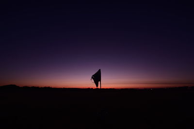 Silhouette horse on landscape against clear sky