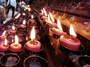 Close-up of illuminated candles in temple