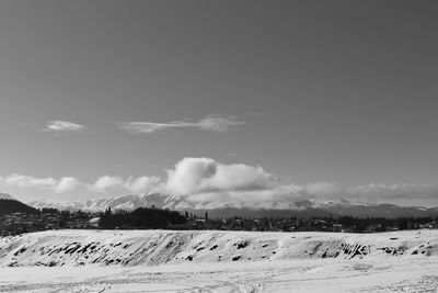 Scenic view of snow covered field against sky